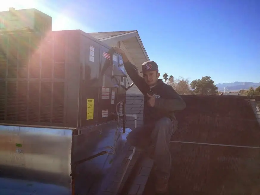 HVAC technician performing AC Tune-Up on a rooftop unit in Hopkinton